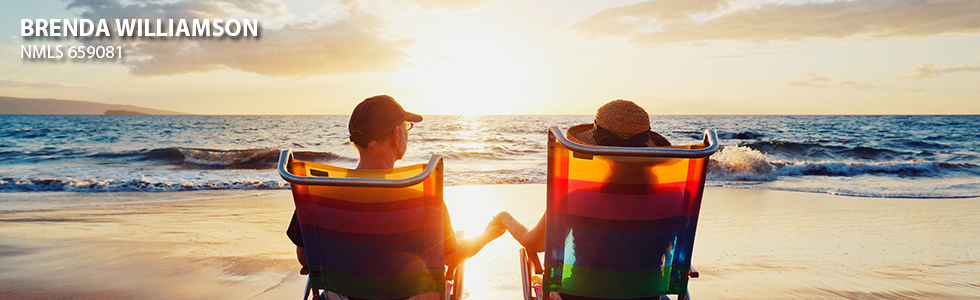 Couple holding hands in lounge chairs on the beach