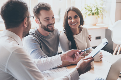 couple signing papers with mortgage advisor