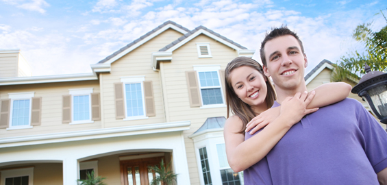 Happy couple in front of their new home