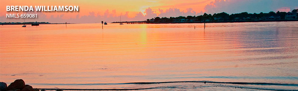 Orange and pink Florida sunset with homes along the water