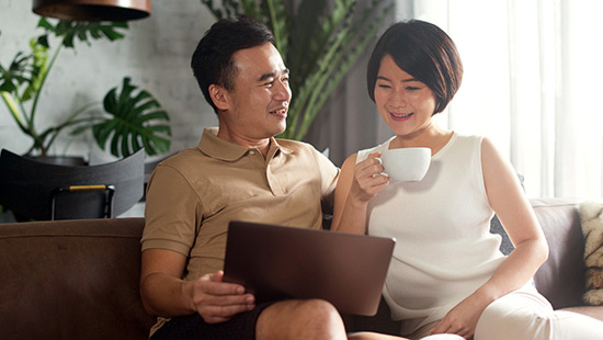 Couple drinking coffee and looking at the computer